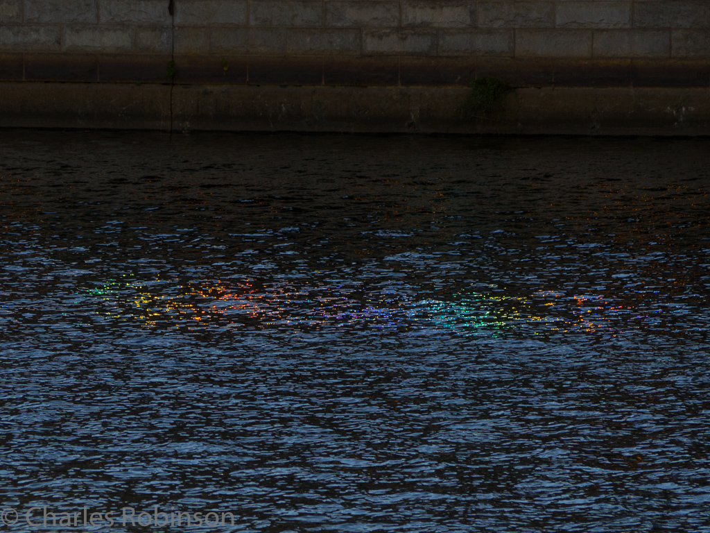 Sitting alongside the Schuylkill River Walk, I noticed that light bouncing through a parking ramp across the street was making rainbows in the river.  Pretty!<br />October 10, 2016@16:56