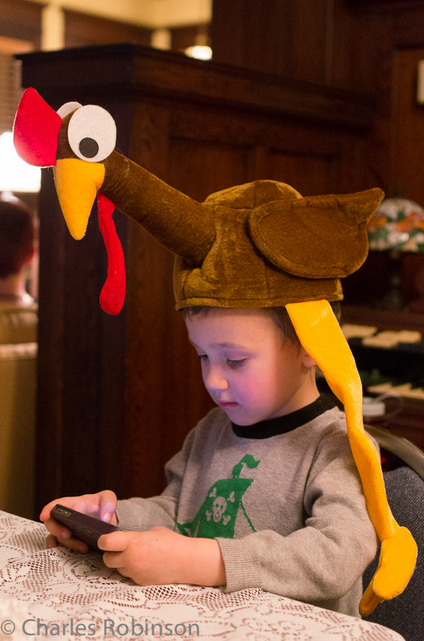 Evan got some quality time with the turkey hat as well - and Grandma's phone for games.<br />November 28, 2013@18:58