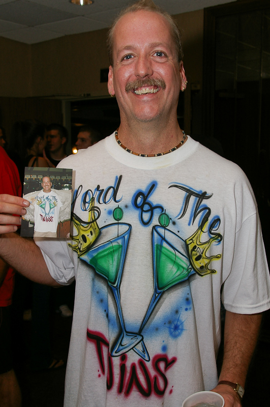 August 05, 2005@23:24<br/>George poses with a photo of himself from last year