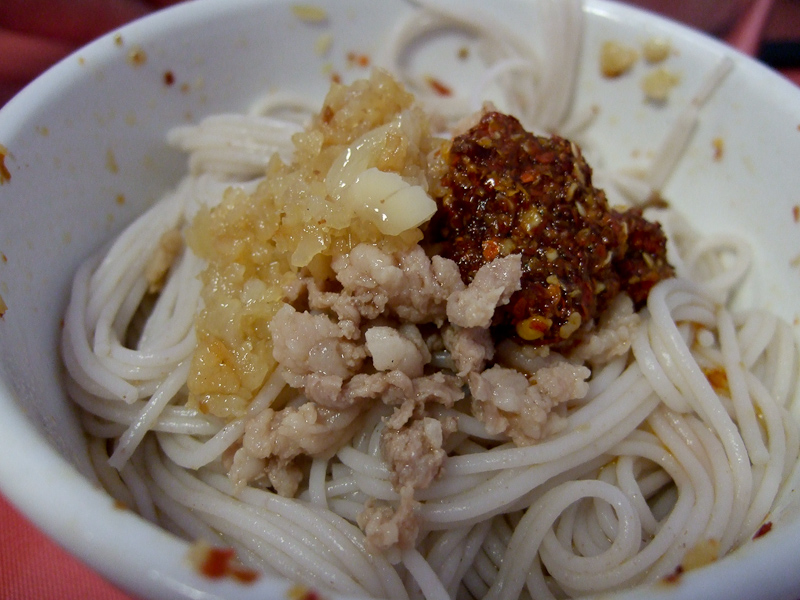 May 01, 2010@08:26<br/>Breakfast!  Noodles with bits of pork, some hot peppers, and garlic to top it off.  (I think this is my second helping)