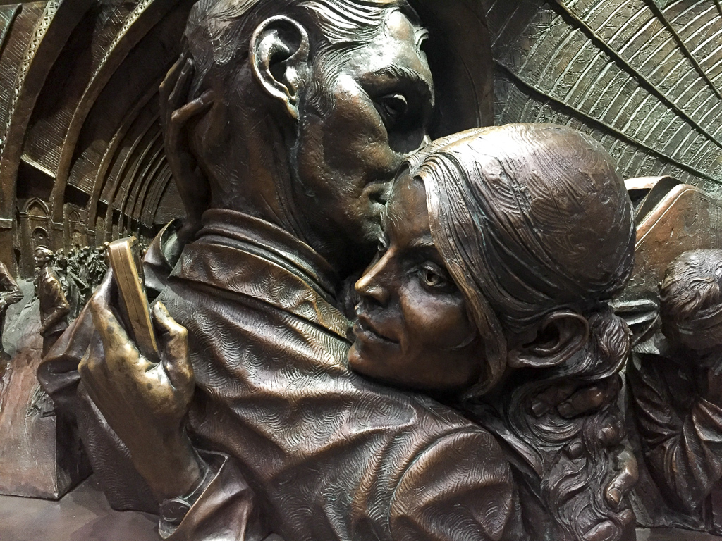 Detail on the base of a statue in St. Pancras station.  Before Melissa pointed it out, I didn't realize she's looking at her phone.<br />May 08, 2017@22:14
